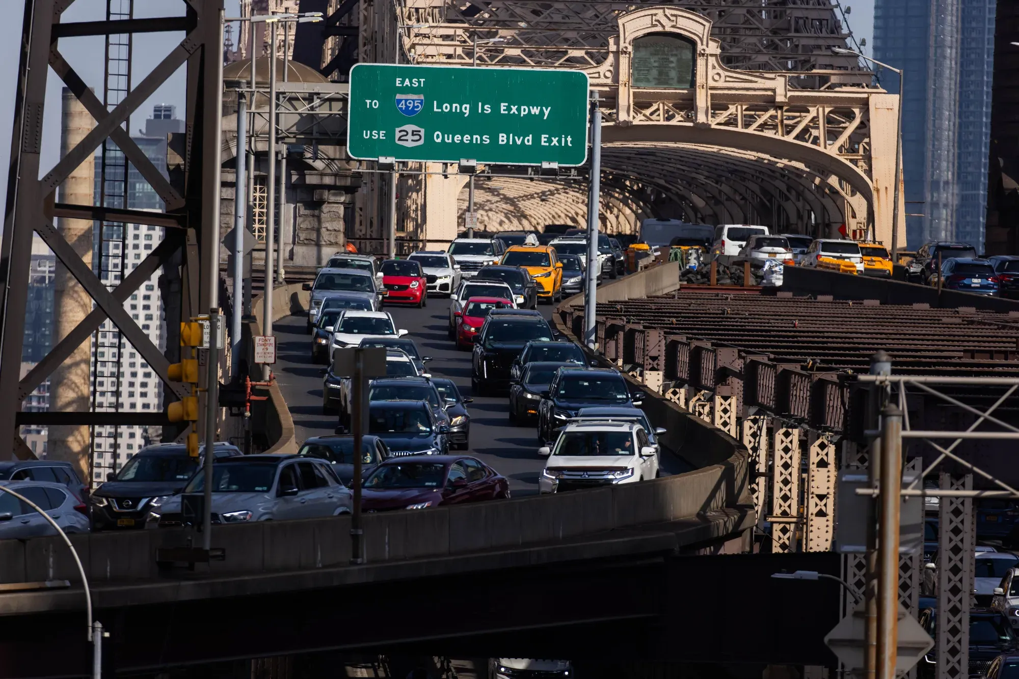 Traffic congestion on the Queensboro Bridge in New York City with the Long Island Expressway sign visible
